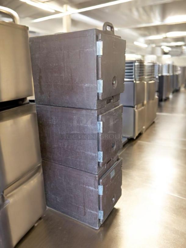Stack of three brown Cambro insulated food transport carriers, model UPC, in prime condition, ready for use.
