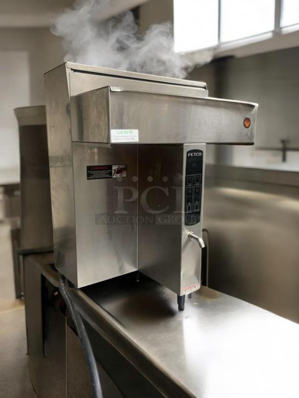 FETCO CBS-2032e commercial coffee brewer in outstanding condition, fully tested and working, stainless steel finish, with operational controls and steam visible.