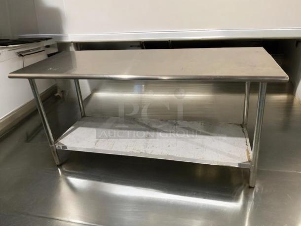 Stainless steel commercial work table in excellent condition, heavy duty, with lower shelf, ready for use.