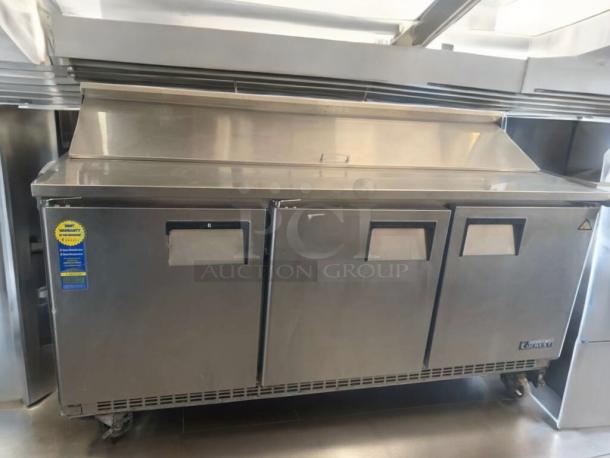 Prime condition Everest EPBNR3 refrigerated prep table with stainless steel finish; features three compartments and mounted casters.