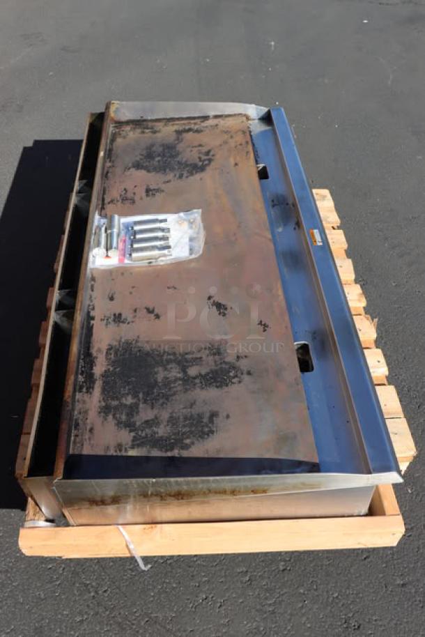 Cooking Performance Group GM-CPG-60-NL griddle, 60" gas, manual controls, 150,000 BTU, mild surface rust, on wooden pallet.