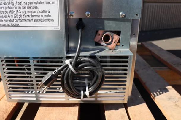 Rear view of a Hoshizaki C-80BAK-AD ice machine. Features air vents, power cord, and metal casing. Possible minor scratches.