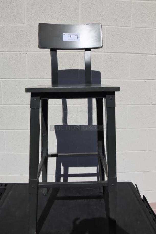 Bar height wood stool with back and footrest, brand new scratch-n-dent condition. Auction tag visible on backrest.