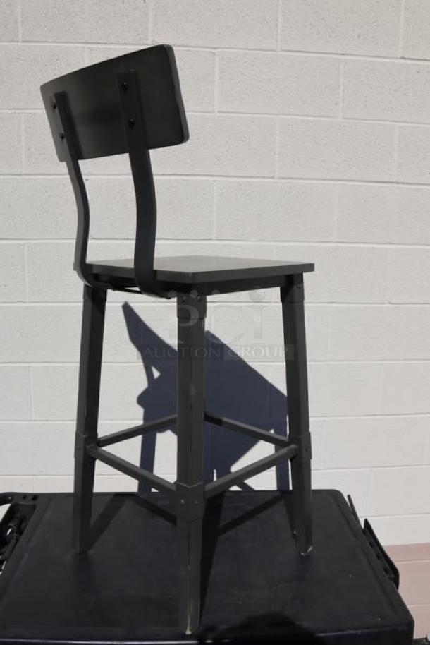 Brand new bar height wood stool with back and footrest, shown in black. Scratch-n-dent condition, 9 units available.