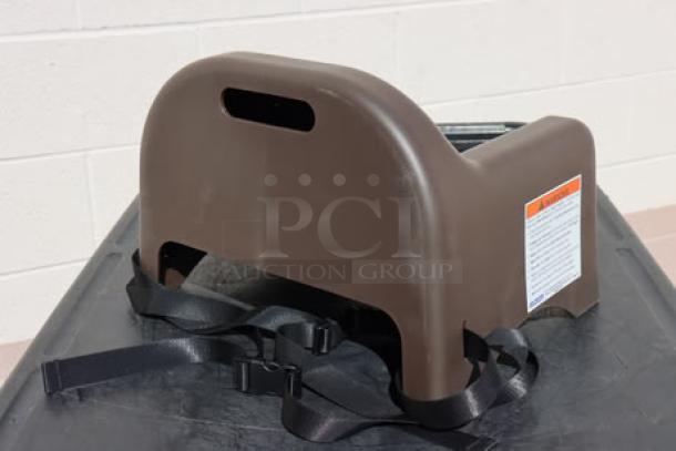 Brand new Carlisle 911401 brown polypropylene booster seat with safety strap, ideal for secure child seating.