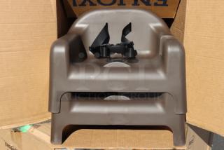 Brand new Carlisle 911401 brown polypropylene booster seat with safety strap, durable design, ideal for child seating.