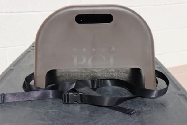 Brand new Carlisle 911401 brown polypropylene booster seat with safety strap, featuring a sleek design for secure seating.