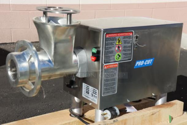 ProCut KG-22-W-XP meat grinder, 220V, 2 hp. Includes auger, knife, pusher, grinder plates. Dented on left. Tags show warnings.
