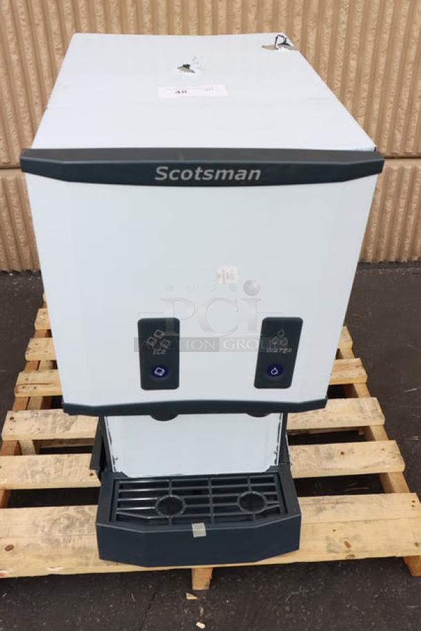 Brand new Scotsman UN1520AX-1 ice machine, 57 lb. bin, air-cooled. Minor scratches. Model HID312ABX-1A visible.