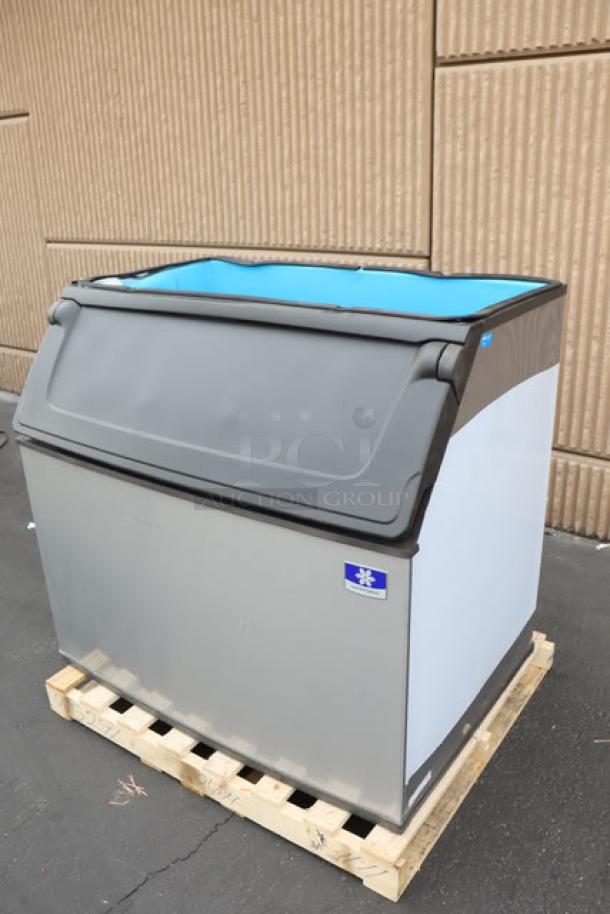 Brand new Manitowoc D970 ice storage bin, 882 lb capacity, minor scratches, S/N: 1121219180, stainless steel exterior.