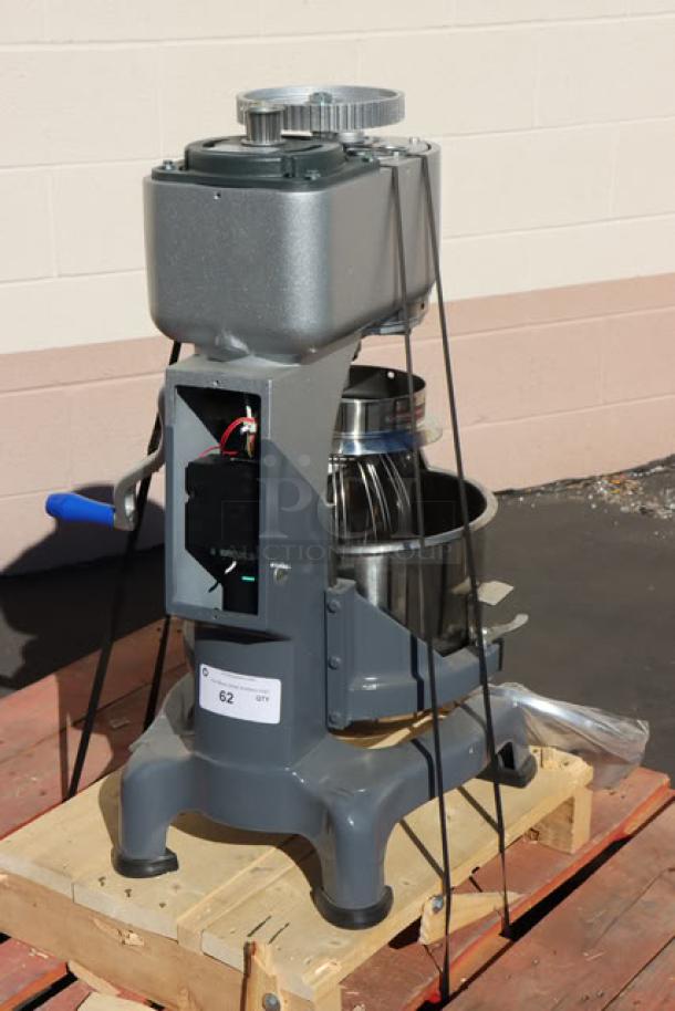 Vollrath 40757 20 Qt. Planetary Stand Mixer on pallet, with visible damage. Includes guard and standard accessories, partially assembled.