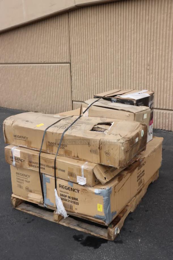 Mixed lot of new kitchen equipment on a pallet with damaged boxes, including Regency sink, Avantco coffee maker, fryer, and more.