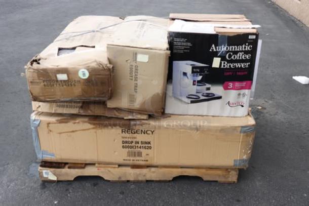 Mixed lot of industrial kitchen equipment on pallet, includes Regency sink, Avantco coffee maker, fryer, and grease trap. Boxes damaged; items may have scratches or missing parts.