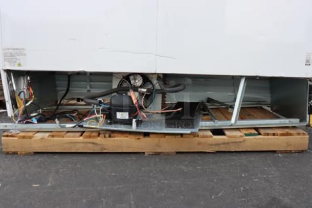 Avantco GDC-69-HC glass door merchandiser refrigerator, showing damaged bottom frame and exposed components, on pallet.