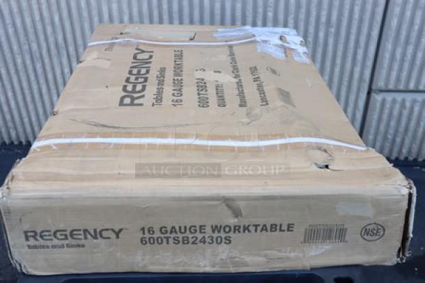 BRAND NEW Regency 600TSB2430S work table in damaged packaging, 24"x30" stainless steel, includes 4" backsplash and undershelf.