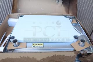 Regency 600TSB2430S stainless steel work table, 24"x30", with 4" backsplash and undershelf. Original packaging damaged.