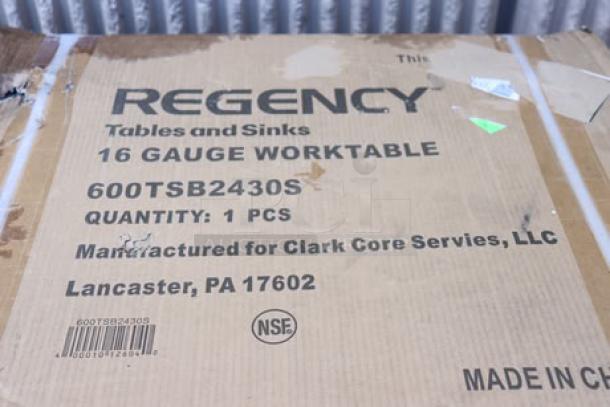 Brand new Regency 600TSB2430S stainless steel work table with 4" backsplash, original packaging damaged, potential scratches.