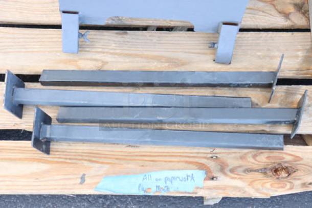 Steel components for outdoor deep fryer on wooden pallet, out of packaging, potential scratches, missing small parts.