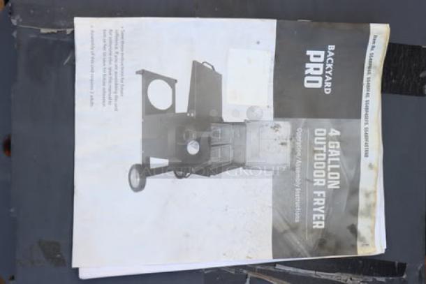 Alt text: Backyard Pro 4 Gallon Outdoor Fryer instruction manual on a table.