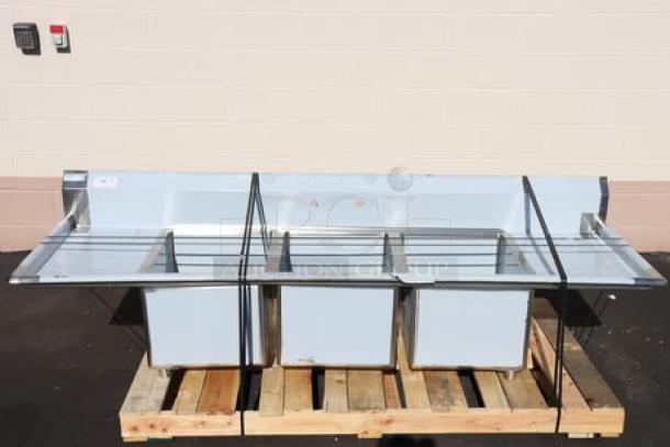 Regency 600S31824218 stainless steel commercial sink with three 18"x24"x14" bowls, double drainboards. Minor scratches/dents.
