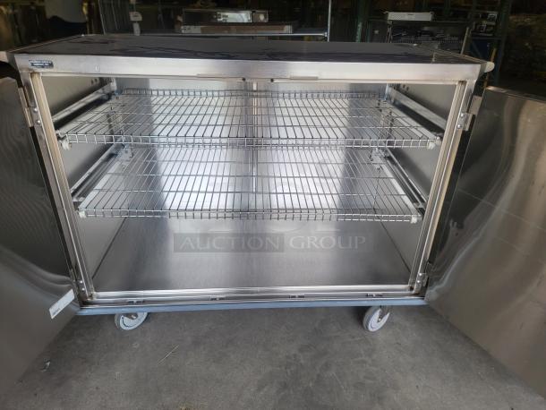 Heavy-duty stainless steel mobile cabinet by Suburban Surgical, model Tote-AL Type C, features two wire shelves, caster wheels, excellent condition.