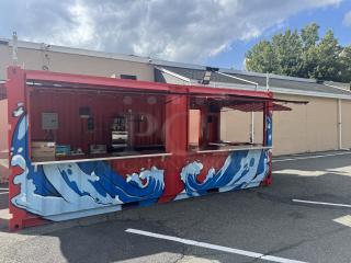 Custom 20' mobile beach bar container with blue wave murals, equipped with beer coolers, sinks, frozen drink machine, and sound system.