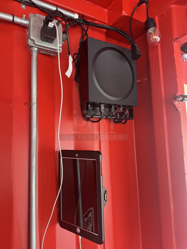 Red interior of the Sandlot Beach Bar container showing a mounted Sonos sound system and iPad controller for easy setup.