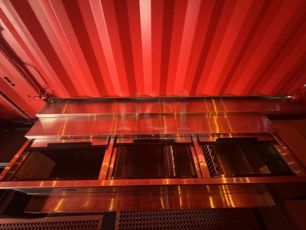 "Interior view of the 20' mobile beach bar container featuring stainless steel service counters and vibrant red walls."