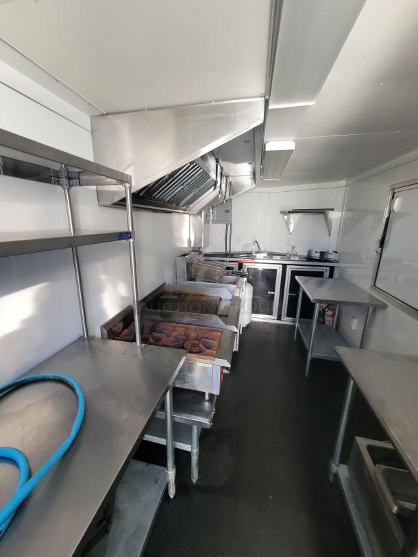 2021 Covered Wagon 16' food trailer interior with griddle, dual grate grill, dual fryers, prep tables, and sink.
