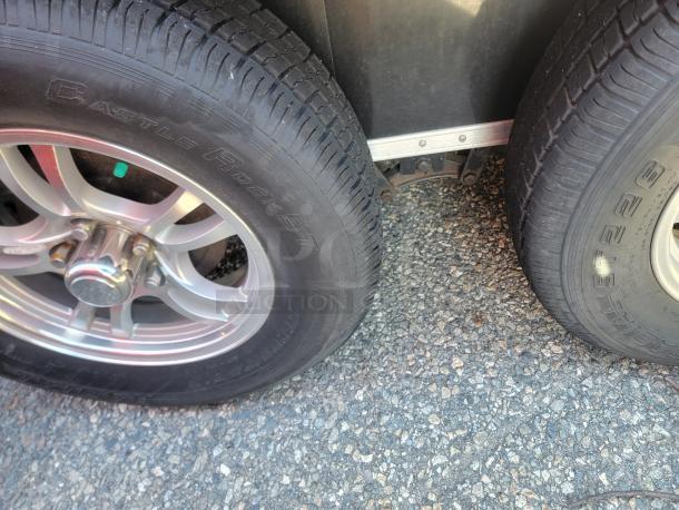 Close-up of wheel and tire on a 2021 Covered Wagon food trailer, featuring Castle Rock ST tires and alloy rims.
