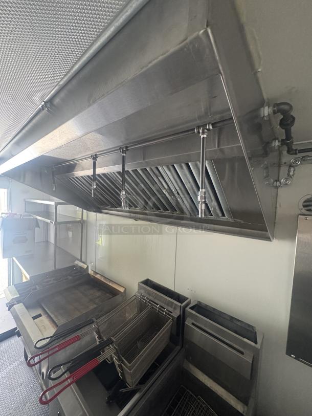 2021 Covered Wagon 16' mobile food trailer interior with commercial kitchen setup, featuring a flat top griddle, dual Anets fryers, and fire suppression system.
