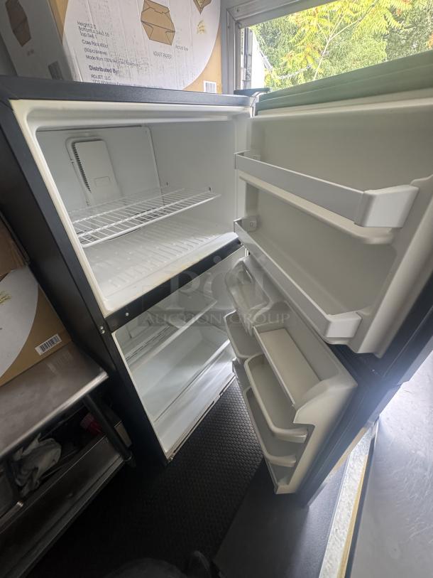 Kenmore fridge/freezer in a 2021 16' mobile food trailer, showing open door, spacious interior, and door shelves.