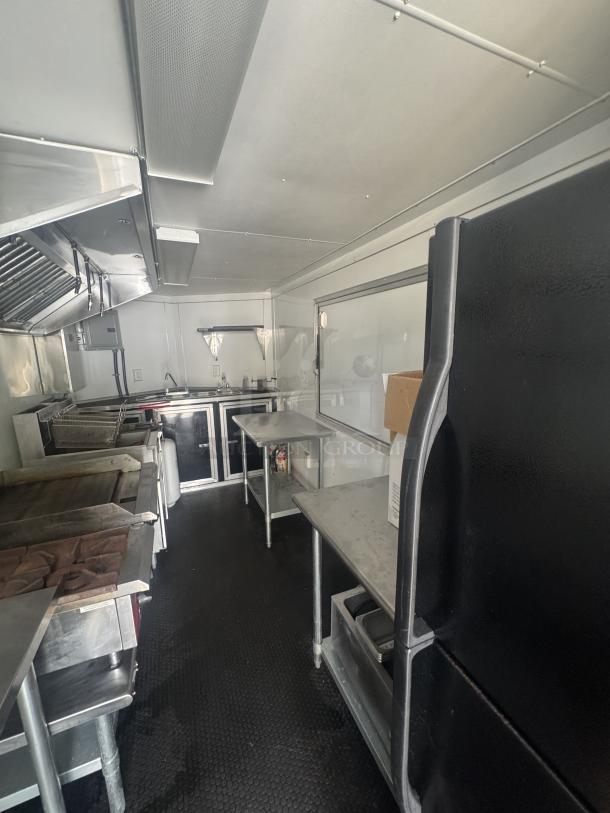 2021 16' Covered Wagon mobile food trailer, features full commercial kitchen with griddle, dual fryers, fridge/freezer, sink, and fire suppression system. Ready for use.