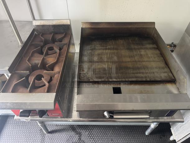 Commercial kitchen with dual grate grill and flat top griddle in a well-maintained 2021 Covered Wagon 16' mobile food trailer.