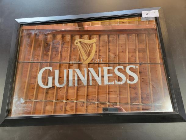 Guinness pub mirror, 40"x29", with gold harp logo and traditional lettering, black frame, evokes authentic pub ambiance.