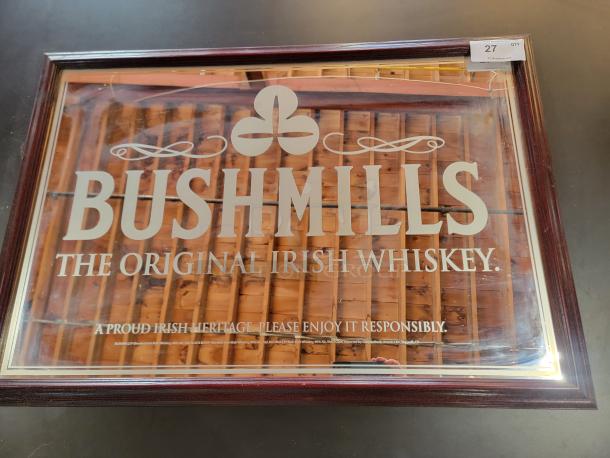 Vintage Bushmills pub mirror, 39"x27", featuring white typography and logo on reflective glass with dark wood frame.