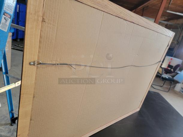 Back view of a vintage Bushmills pub mirror, 39"x27", with a sturdy dark-stained wood frame and hanging wire.