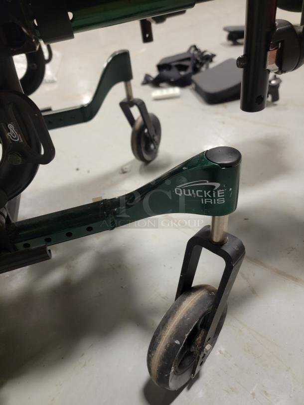 Quickie IRIS Tilt-in-Space Wheelchair, green frame, visible smooth caster, logo on frame; excellent condition.