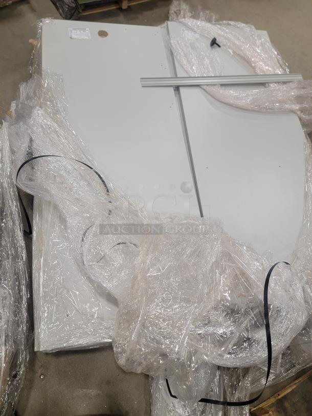 Set of AIS Matrix 6'x6' cubicles wrapped for transport. Includes glass tiles and height-adjustable tables. Like new condition.