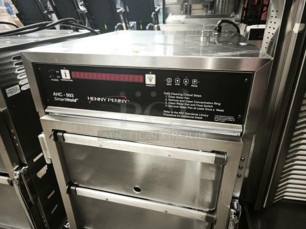Brand new Henny Penny AHC-993 SmartHold humidified heated pass-thru holding cabinet, 120V, with cleaning instructions visible.