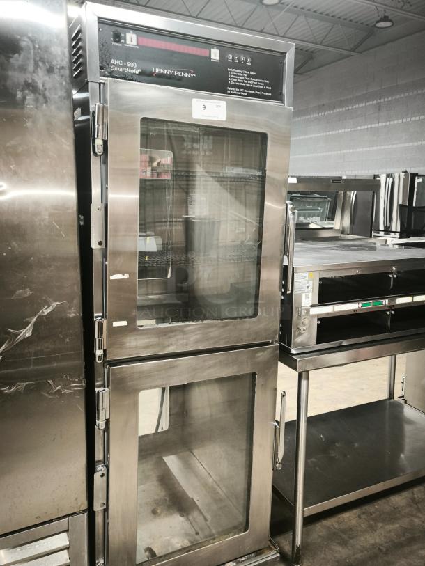 Brand new Henny Penny AHC-990 Smart Hold heated holding cabinet on casters, stainless steel finish, 240v/1ph, with glass doors.