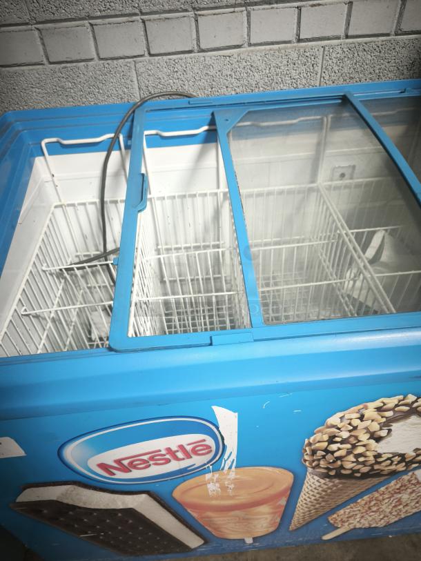 AHT RIO S 100 commercial chest freezer merchandiser on casters, missing right side glass pane, tested and working.