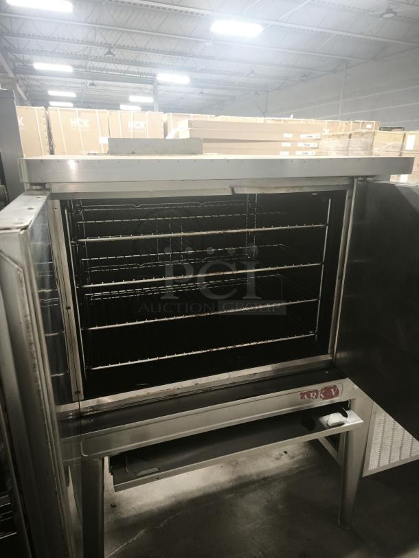 BLODGETT commercial electric convection oven, open door, interior racks visible, silver finish, industrial setting.