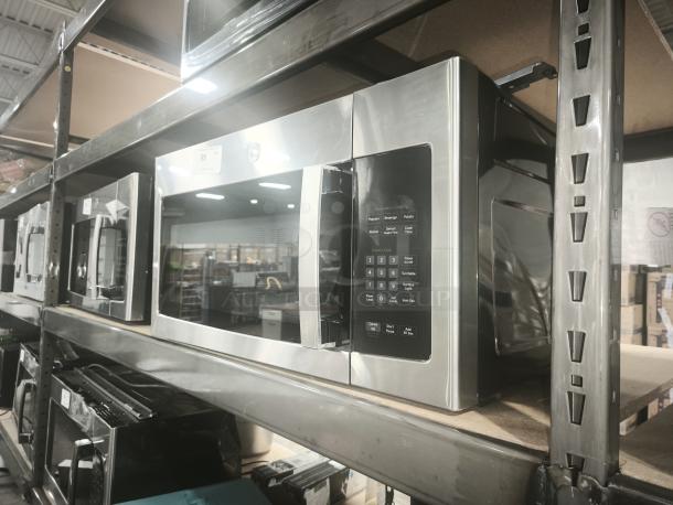 Brand new GE 1.6 Cu. Ft. Over-the-Range Microwave Oven, model JNM3163RJ6SS, on display. Stainless steel finish, keypad visible.