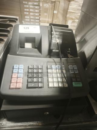 Sharp XE-A22S cash register, 14x14x12 inches, in used condition. Features numeric keypad, receipt print slot. Visible auction tag.