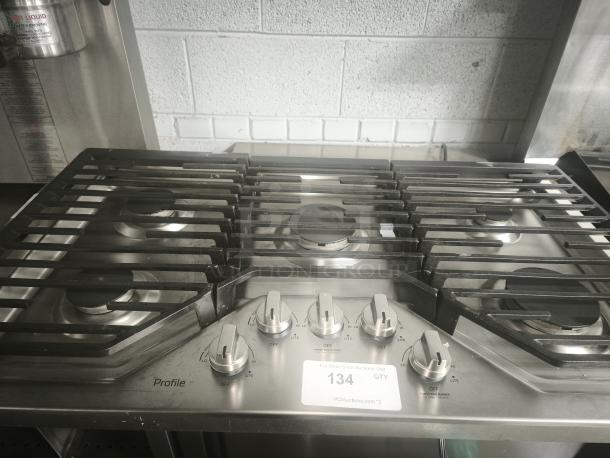 Profile 36 in. gas cooktop, model PGP7036SLSS, stainless steel, 5 burners with power boil, like new condition, visible control knobs.