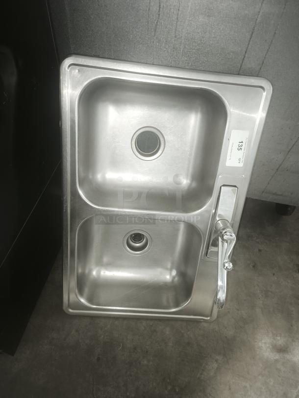 Stainless steel drop-in double sink with faucet, good condition, label indicates item number 135.