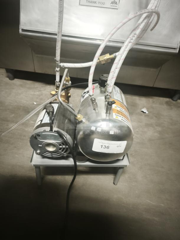Stainless Steel Air Compressor Pump, compact and quiet on stand, with visible labels and hoses, tag reads "136 QTY".