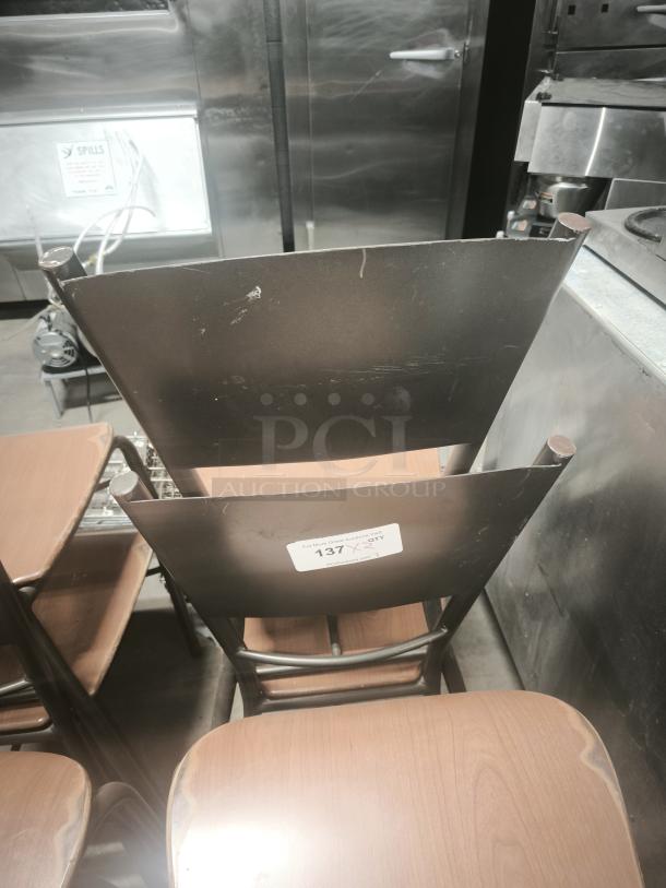 Brown dining chairs with bronze metal bases. Visible wear on backrest. Label shows "137" indicating quantity or lot number.