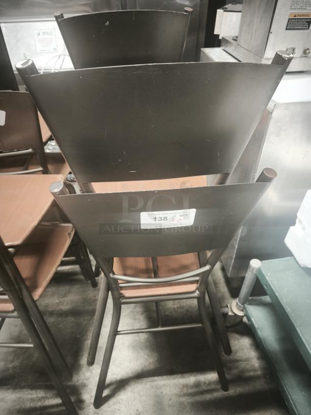 Metal dining chairs with bronze base, stackable design. Label indicating auction number 138. Slight wear visible.